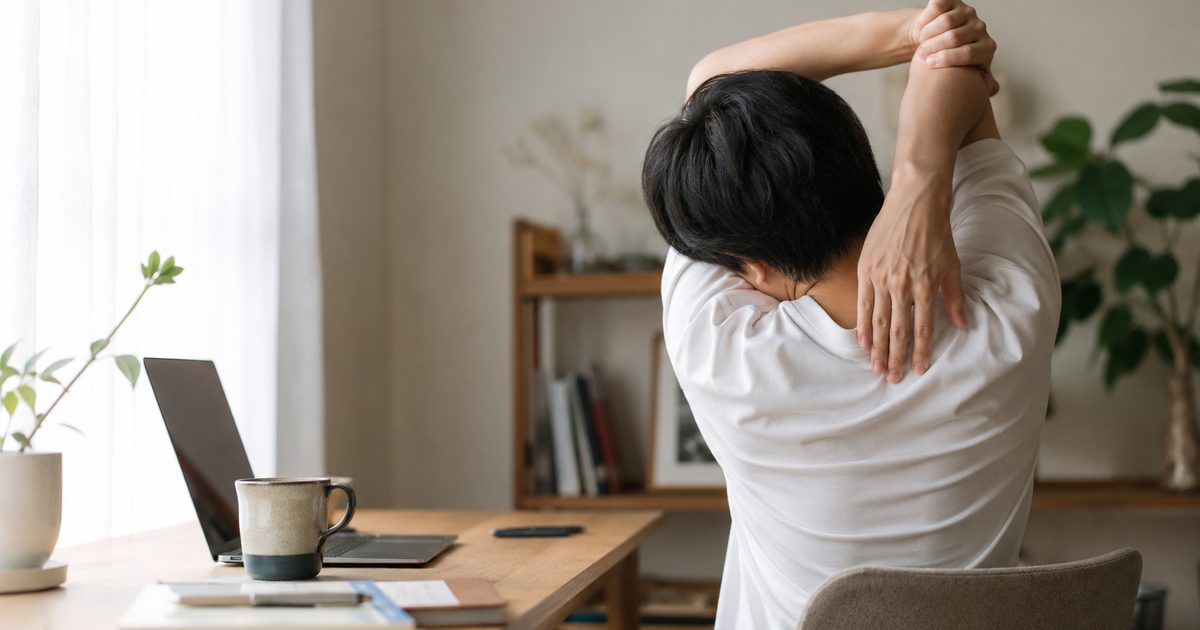 自宅デスクで肩と首をストレッチする様子